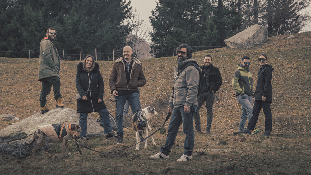 Group of friends looking really hip and cool on the mountains of Lake Como with two dogs and moody colors.